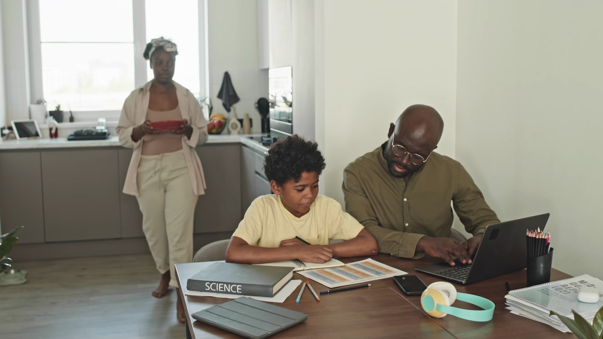 Family engaged in online learning with a laptop